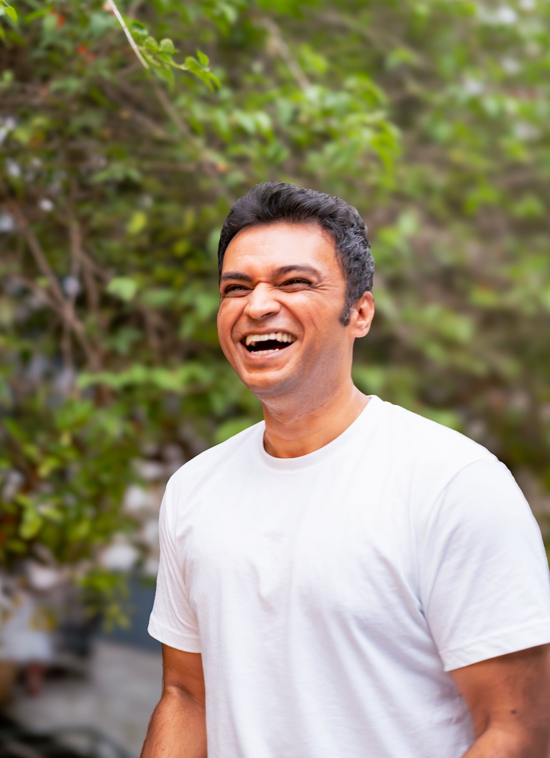 Vishal, breathwork facilitator, laughing outdoors among trees